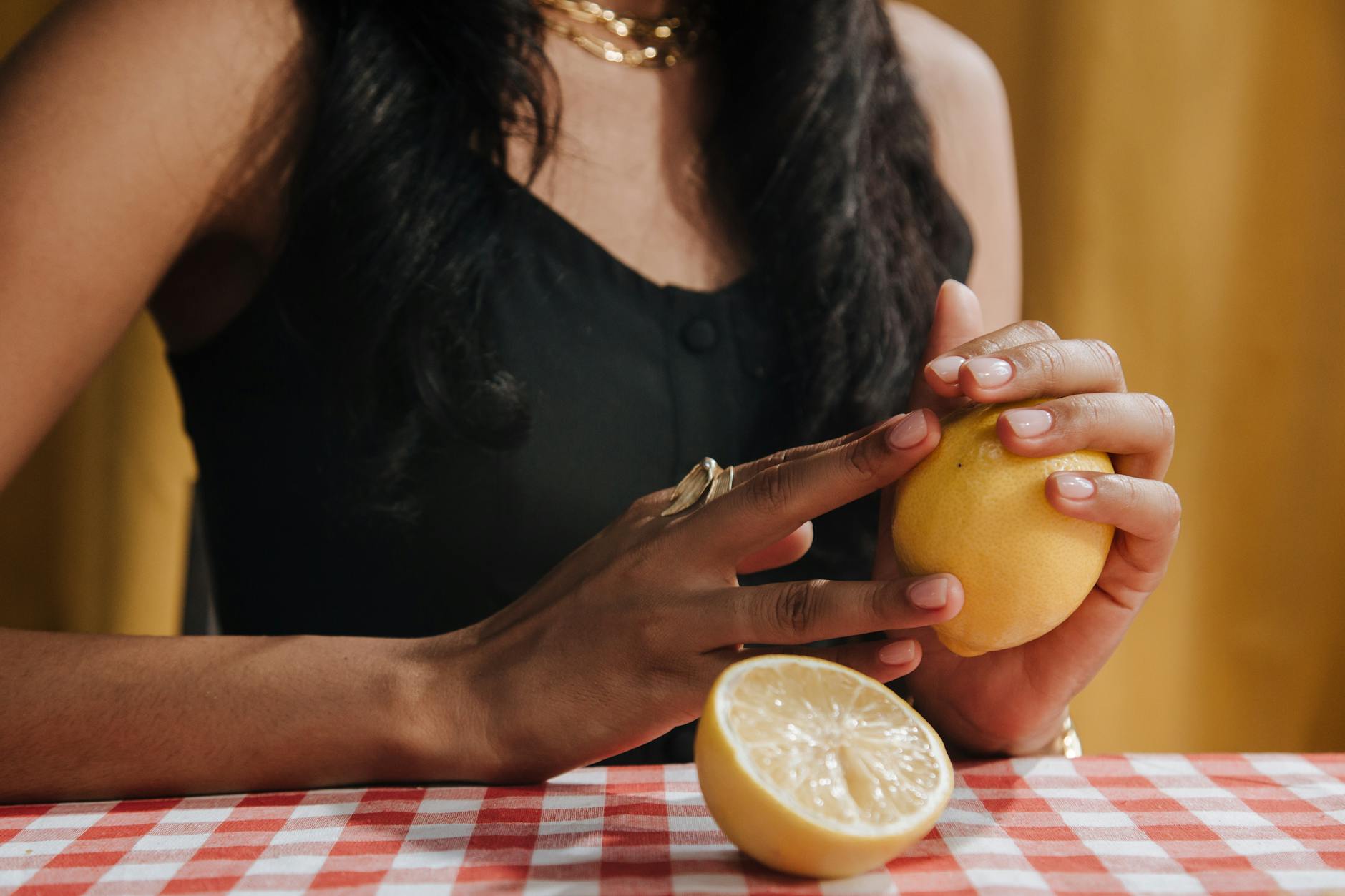 A hand holding an orange vibrator against a minimalistic purple backdrop, showcasing modern sensuality.